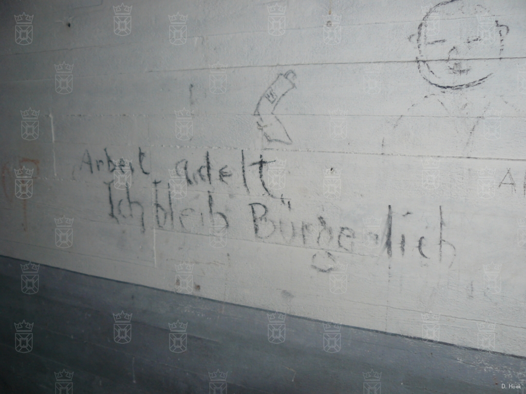 De tekst "Arbeit adelt. Ich bleib Bürgerlich." staat op de wand in een van de munitieruimten.