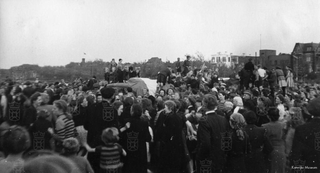 Een uitzinnige menigte beklimt de wagens van de RAF die bij de Duinoord aangekomen zijn.